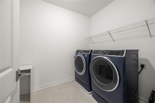 laundry area featuring laundry area, washing machine and dryer, and baseboards