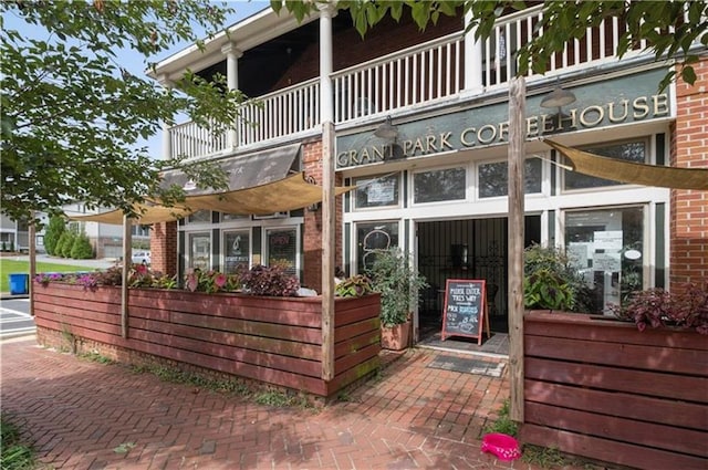 rear view of property with a balcony and brick siding