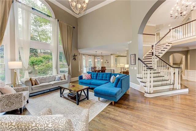 452 Brushstroke Ct SE, Marietta, GA 30067 - living room with a chandelier, a high ceiling, arched walkways, crown molding, and stairs
