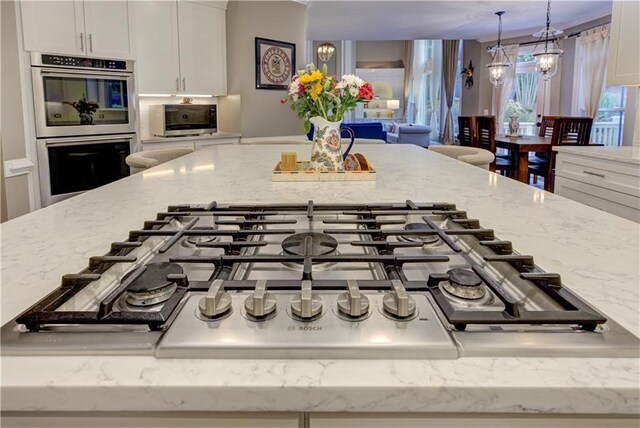 452 Brushstroke Ct SE, Marietta, GA 30067 - kitchen view of stainless steel appliances, light stone countertops, white cabinetry, and hanging light fixtures