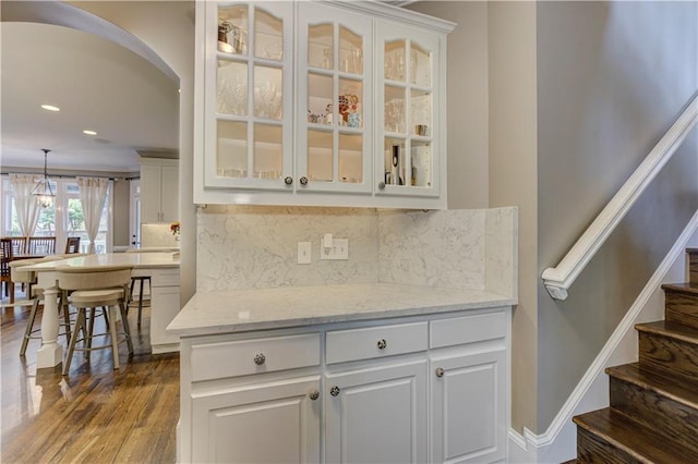 452 Brushstroke Ct SE, Marietta, GA 30067 - bar with stairs, dark wood-style flooring, recessed lighting, backsplash, and arched walkways