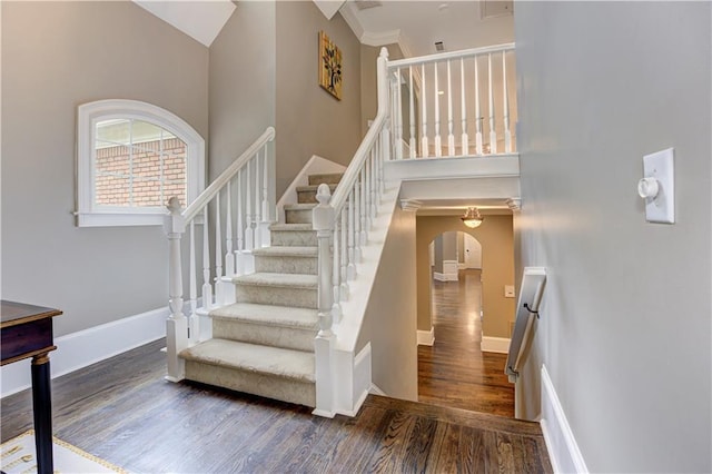 452 Brushstroke Ct SE, Marietta, GA 30067 - staircase featuring a towering ceiling, arched walkways, wood finished floors, and baseboards