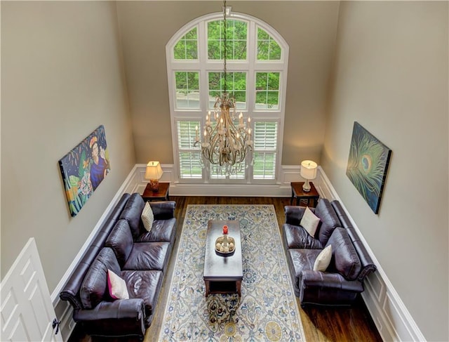 452 Brushstroke Ct SE, Marietta, GA 30067 - living area featuring a chandelier, a decorative wall, wood finished floors, a wainscoted wall, and a towering ceiling