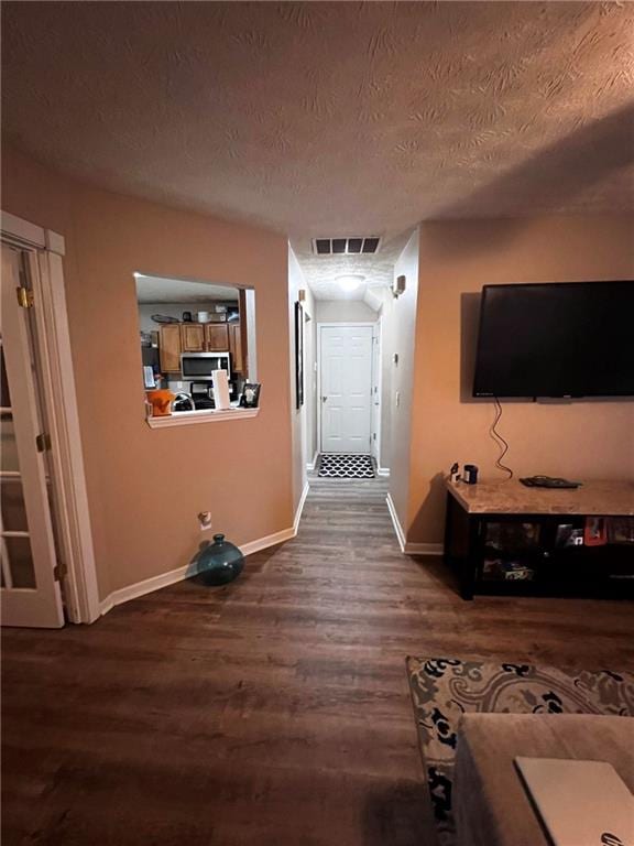 interior space featuring a textured ceiling and dark hardwood / wood-style flooring