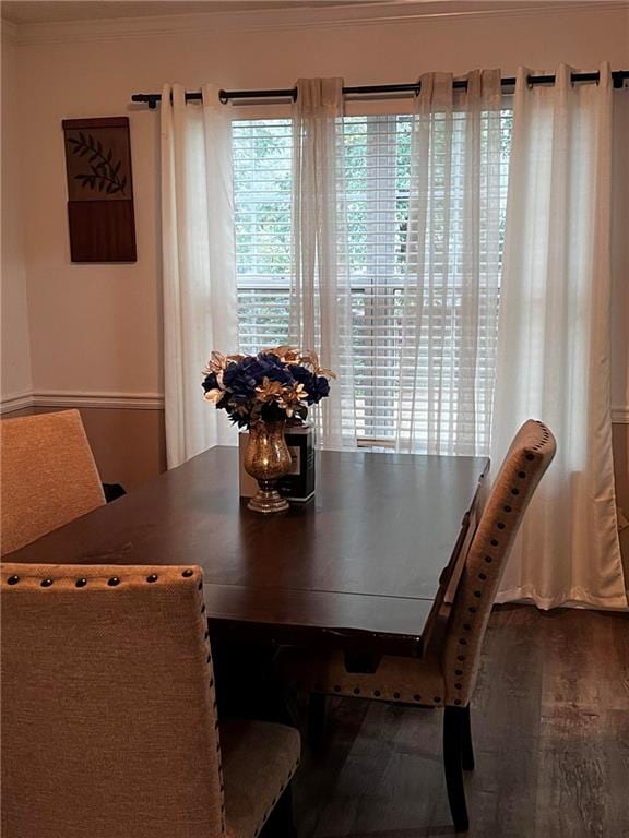 dining space with crown molding and hardwood / wood-style flooring