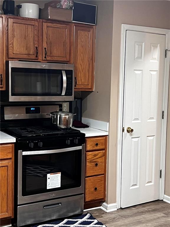 kitchen with hardwood / wood-style floors and stainless steel appliances