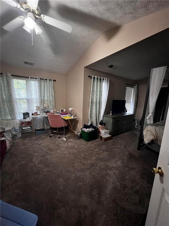 interior space with a textured ceiling, vaulted ceiling, and ceiling fan