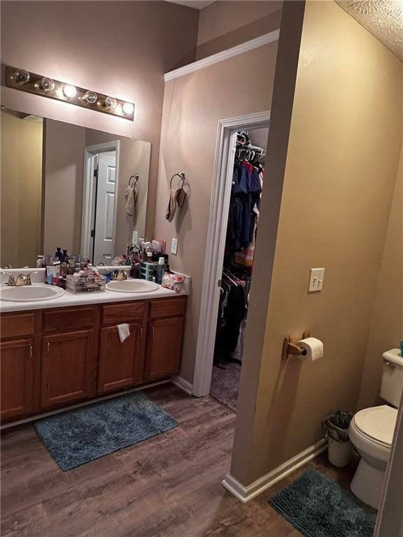 bathroom featuring wood-type flooring, vanity, and toilet