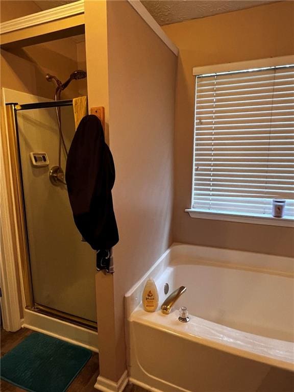 bathroom featuring a textured ceiling and independent shower and bath