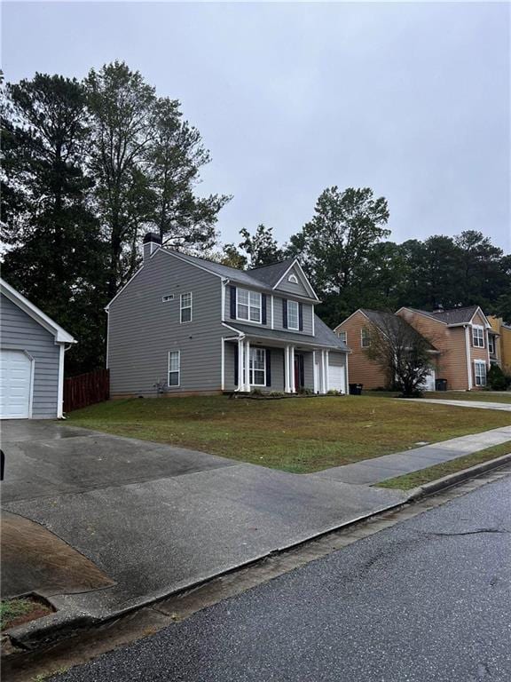 view of front of home with a front yard and a garage