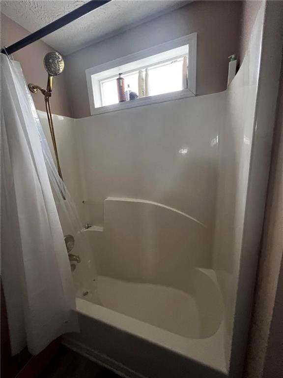 bathroom featuring a textured ceiling and shower / bath combo