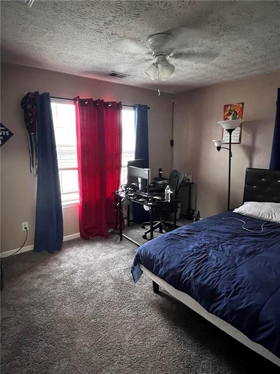 carpeted bedroom with ceiling fan, a textured ceiling, and multiple windows