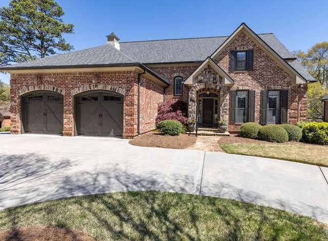 view of front of property featuring concrete driveway, an attached garage, and brick siding