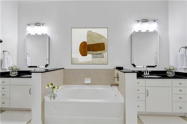 full bathroom with two vanities, a garden tub, and a sink