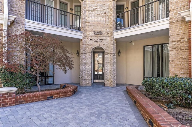 property entrance with brick siding and stucco siding