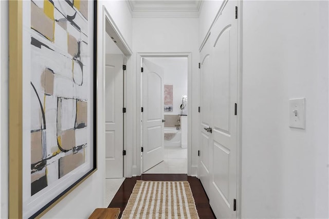 corridor with dark wood-type flooring and ornamental molding