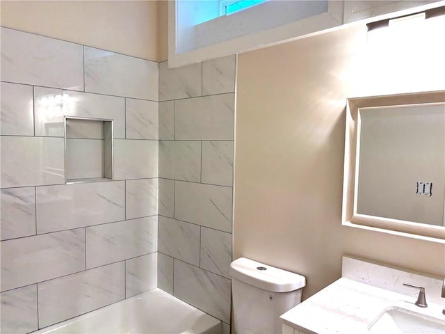 full bathroom with vanity, tiled shower / bath combo, and toilet