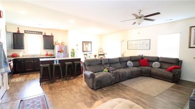 living room featuring light hardwood / wood-style floors and ceiling fan