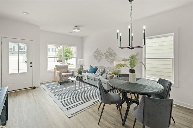 dining space featuring a notable chandelier and light hardwood / wood-style flooring