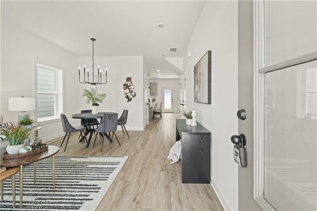 living room with light hardwood / wood-style flooring and a chandelier