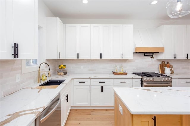 kitchen featuring stainless steel appliances, custom exhaust hood, and white cabinetry