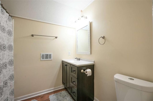 bathroom featuring vanity, toilet, and hardwood / wood-style floors