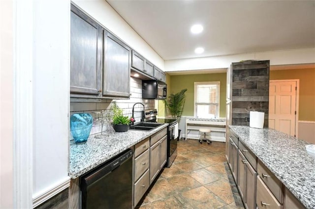 kitchen with light stone counters, sink, decorative backsplash, and black appliances