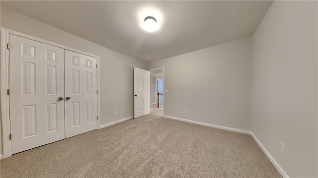 unfurnished bedroom featuring light colored carpet and a closet