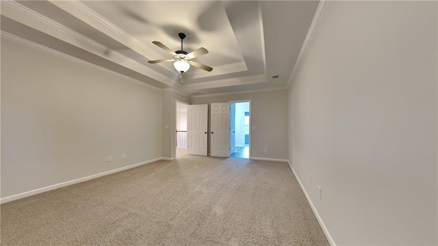 spare room with crown molding, ceiling fan, a tray ceiling, and carpet floors