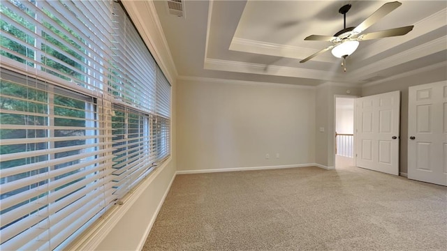 unfurnished room with ceiling fan, ornamental molding, and a raised ceiling