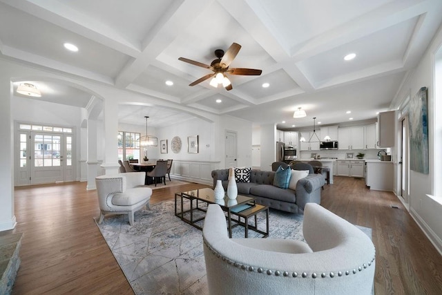 living room with beamed ceiling, coffered ceiling, and hardwood / wood-style flooring