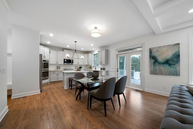 dining space featuring dark hardwood / wood-style flooring, sink, french doors, and a chandelier