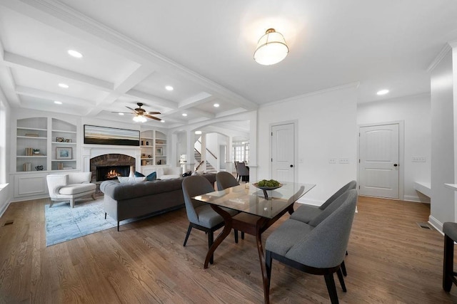 dining space featuring coffered ceiling, hardwood / wood-style floors, built in features, and beamed ceiling