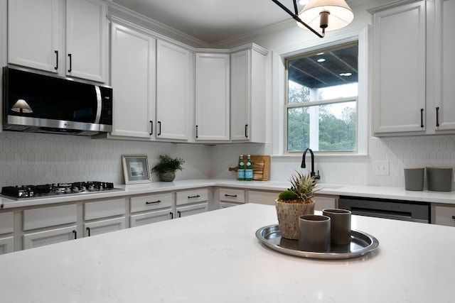 kitchen with stainless steel appliances, white cabinetry, sink, and tasteful backsplash