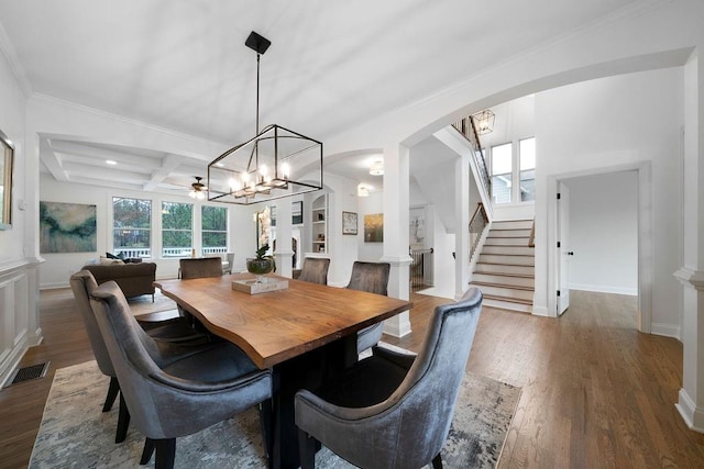 dining space with beamed ceiling, hardwood / wood-style flooring, ornamental molding, coffered ceiling, and a notable chandelier