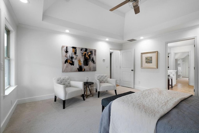 carpeted bedroom with crown molding, a tray ceiling, and ceiling fan