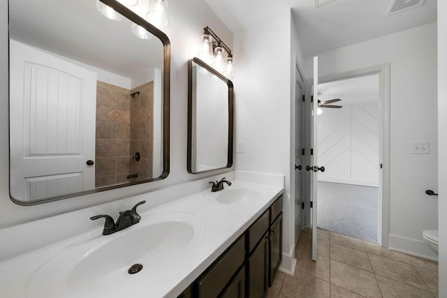 bathroom featuring vanity, tiled shower, tile patterned floors, and toilet