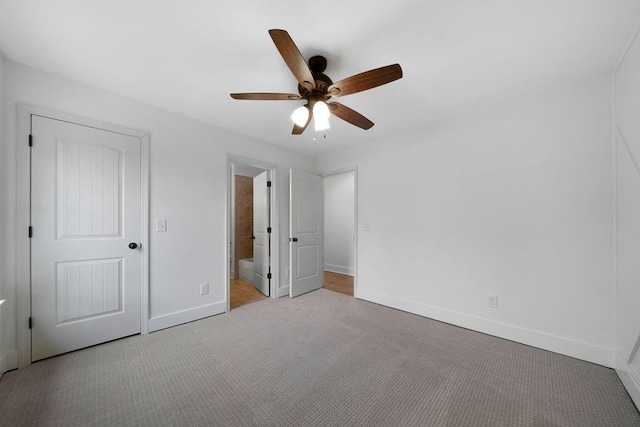 unfurnished bedroom with ceiling fan, light colored carpet, and ensuite bath