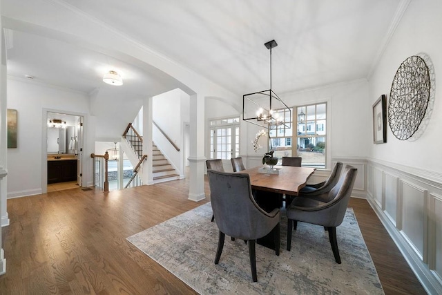 dining area featuring ornamental molding, a notable chandelier, and dark hardwood / wood-style flooring