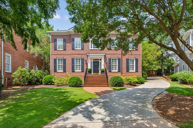 colonial-style house featuring a front yard