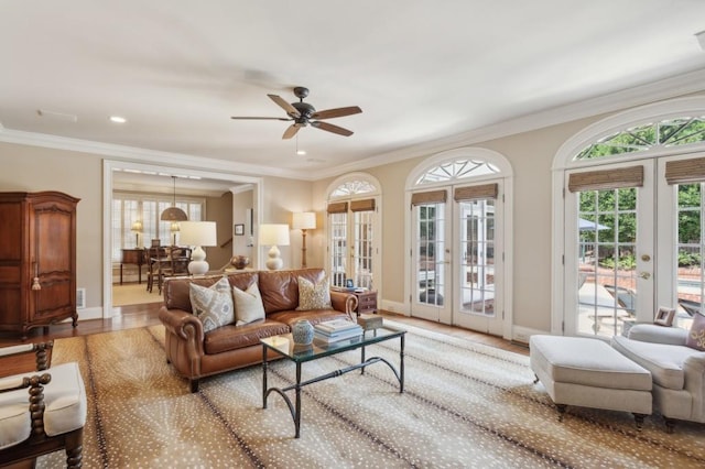 living room with ceiling fan, hardwood / wood-style flooring, ornamental molding, and french doors