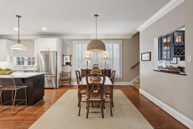 dining space with crown molding and hardwood / wood-style floors