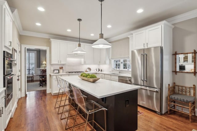 kitchen featuring a wealth of natural light, a kitchen island, hardwood / wood-style floors, and stainless steel appliances