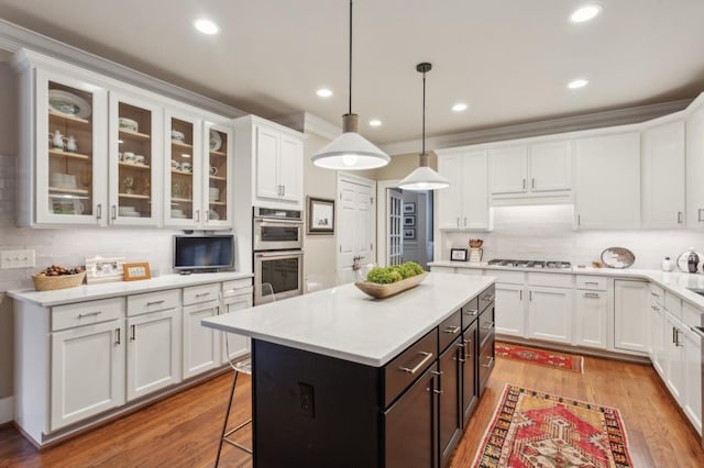 kitchen with light wood-type flooring, appliances with stainless steel finishes, and white cabinetry