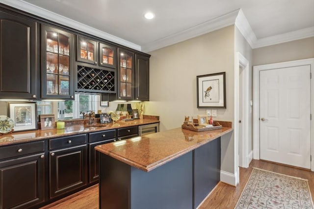 bar with stone countertops, light hardwood / wood-style flooring, ornamental molding, and dark brown cabinets