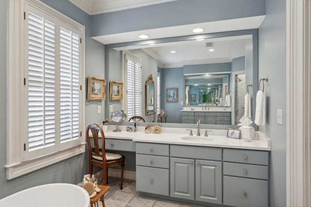 bathroom with a tub to relax in, ornamental molding, vanity, a healthy amount of sunlight, and tile patterned floors