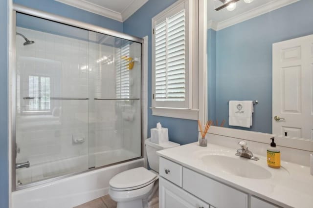 full bathroom featuring shower / bath combination with glass door, ornamental molding, vanity, a healthy amount of sunlight, and toilet