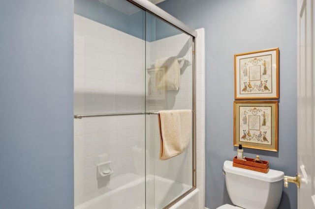 bathroom featuring enclosed tub / shower combo and toilet