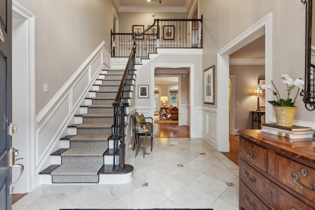 entryway with light hardwood / wood-style floors and ornamental molding