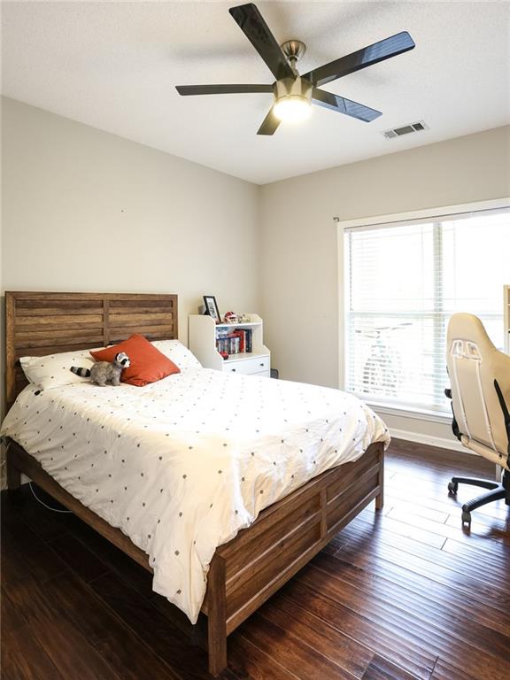 bedroom with dark hardwood / wood-style flooring and ceiling fan